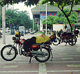 Motorcycle Taxi, Complete with Rider Taking-5. This Machine Appears to Feature the Latest in Ergonomic Design